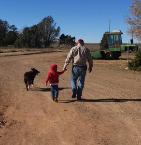 man child dog walking toward farm tractor