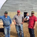 three men and baby on the farm